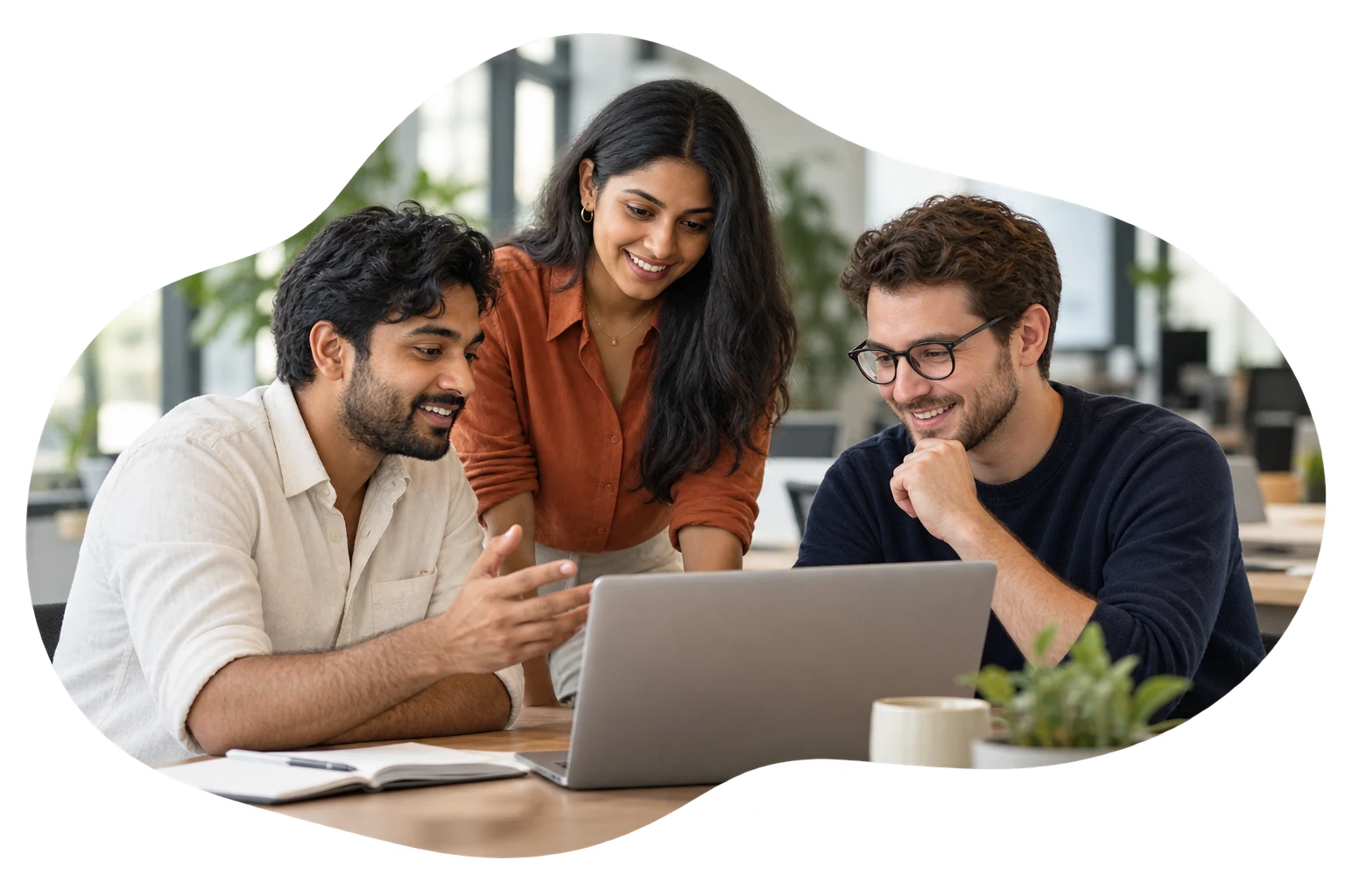 A team discussing a software project around a laptop